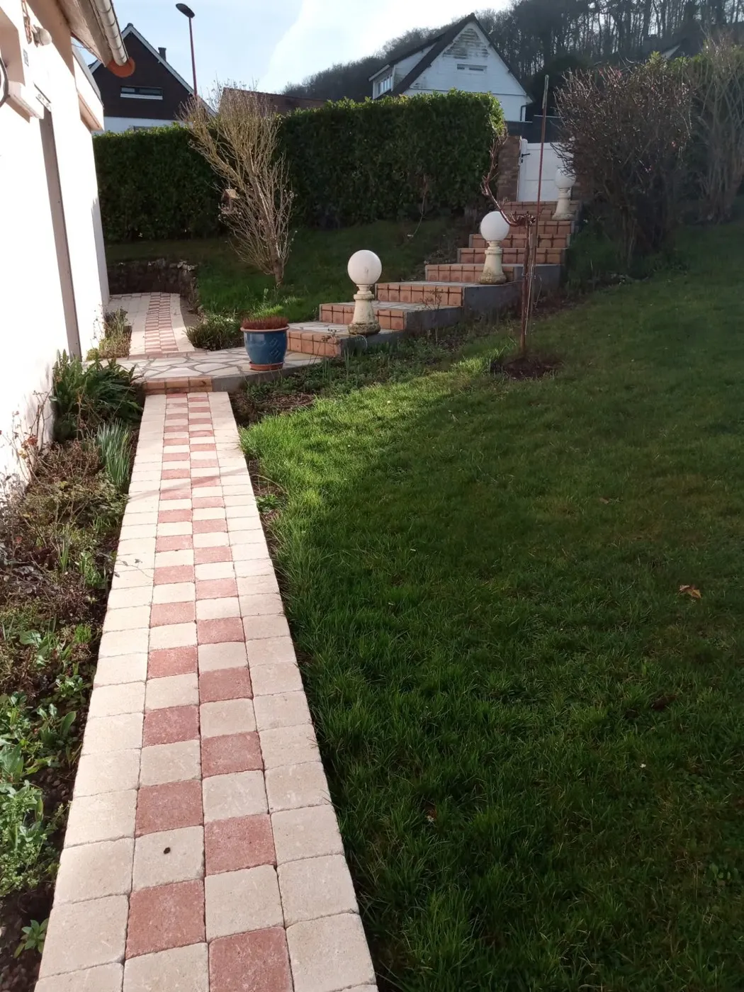 Jardin en pente remis au propre : allée, emmarchement et pelouse tondue